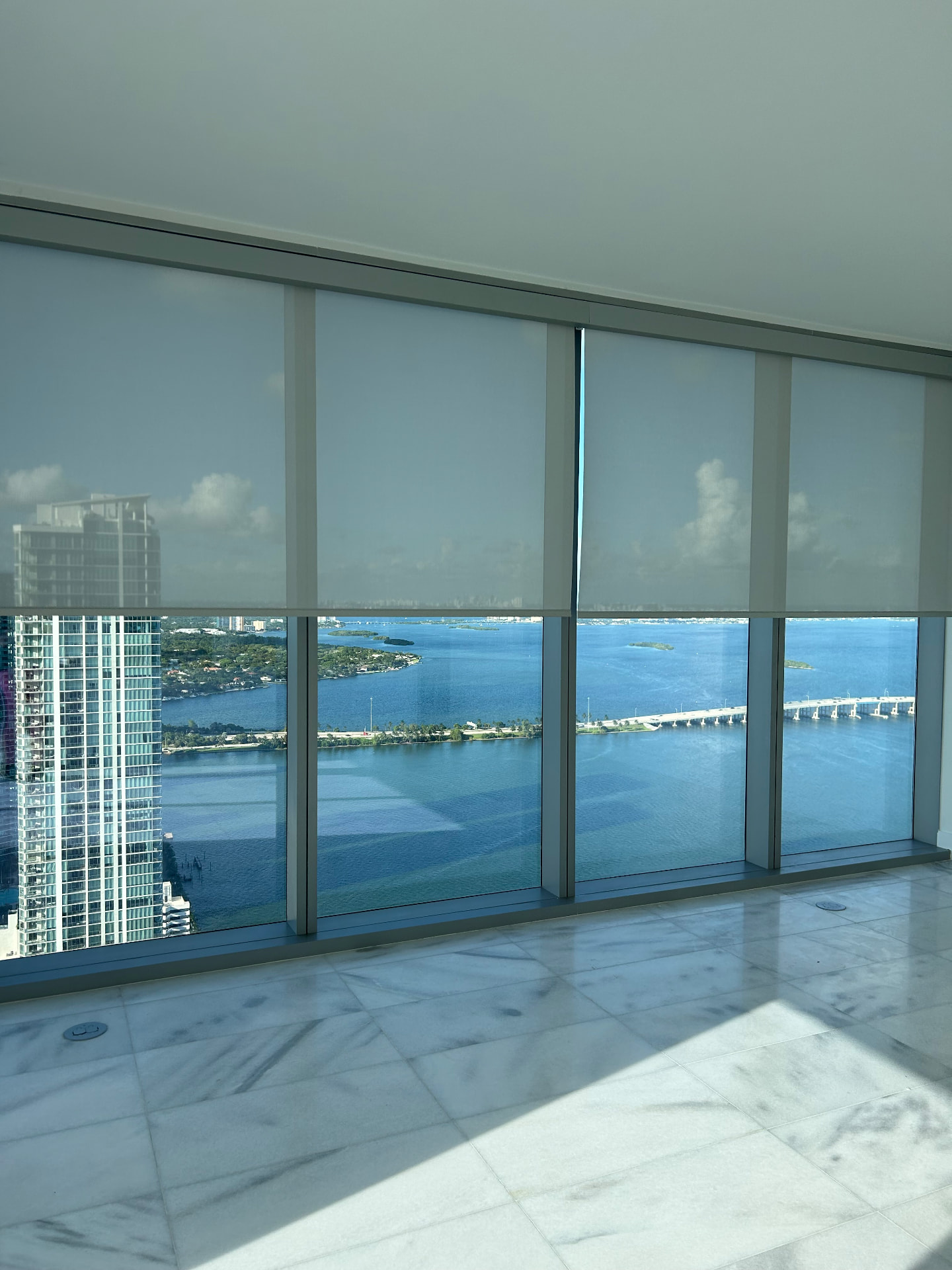 Missoni Baia living room with solar roller shades over a bay view