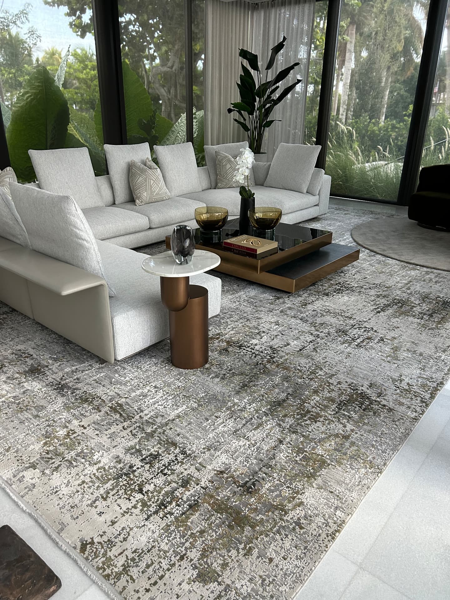 Waterfront estate lounge with floor-to-ceiling sheer drapery facing the garden