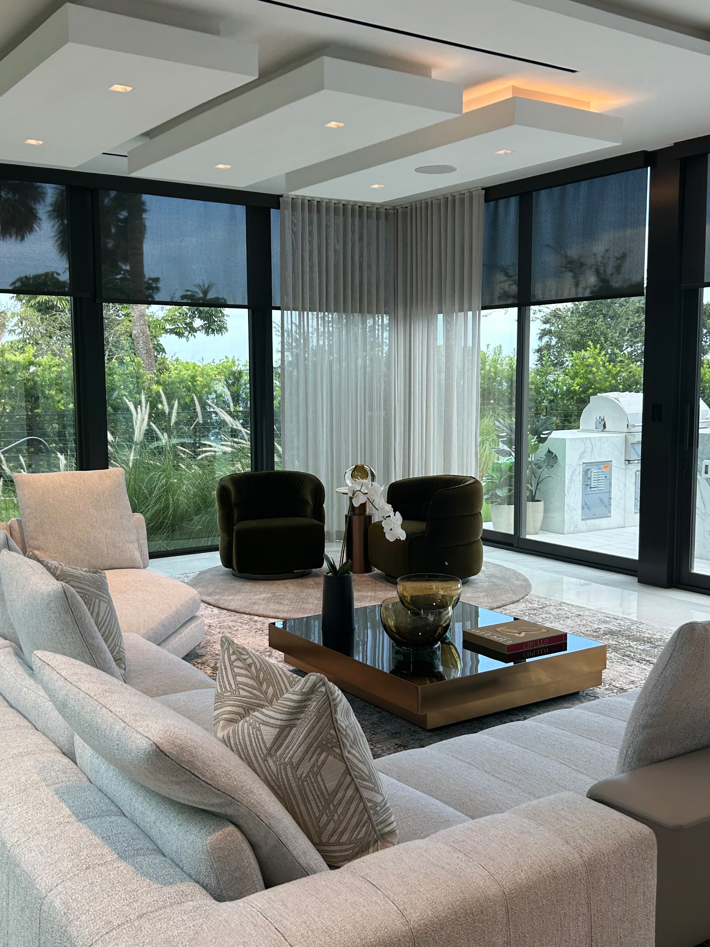 Waterfront estate great room with solar shades and ripple fold sheer drapery